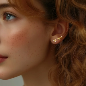 Close-up of gold 925 silver star earrings with pavé crystals on ear