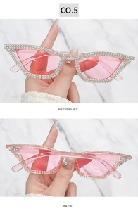Close-up of cat-eye sunglasses with pink lenses and silver rhinestones, 45-degree angle view