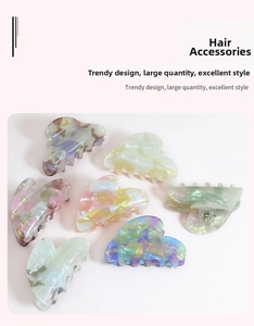 Detailed view of colorful heart-shaped acrylic hair claws with marble texture patterns