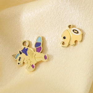 Gold unicorn and elephant enamel charms made of stainless steel on silk background
