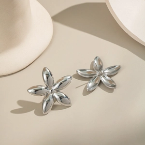 Vue rapprochée de boucles d'oreilles fleur en acier inoxydable argenté poli pour femme