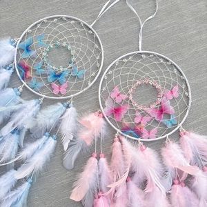 Pink and blue dreamcatchers with delicate feathers and butterfly decor for wall hanging
