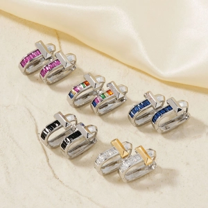 Close-up of T-shaped earrings with five colorful crystal pavé settings and gold finish