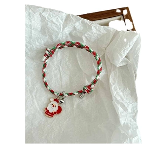 Adjustable Christmas woven bracelet with Santa Claus charm and silver bell on white background