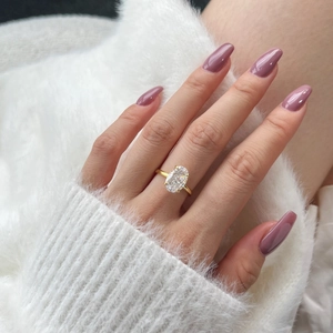 Detailed close-up of a large oval-cut clear gemstone ring on a golden band