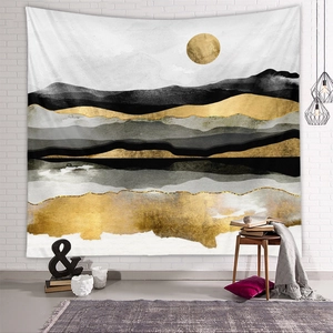 Detail of abstract mountain tapestry with gold and black fluid texture on a white brick wall