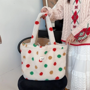 Detail of soft plush tote bag with colorful polka dots and a small woven label