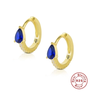 Detailed macro view of S925 sterling silver hoop earrings with blue pear-cut gemstone
