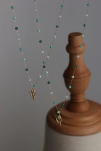 Close-up of vintage tulip pendant necklace with green beads and 18K gold plated chain