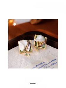 Vue macro détaillée de boucles d'oreilles carrées en émail avec perles baroques