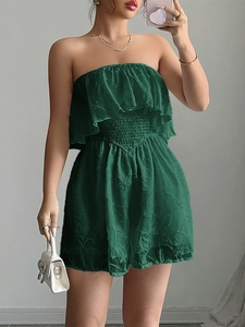 Dettaglio della tutina a fascia verde scuro con balze e tessuto jacquard strutturato