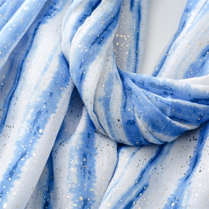 Detail of blue and white tie-dye scarf featuring elegant gold foil speckle patterns