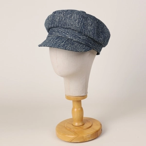 Blue denim texture newsboy cap for women with octagonal crown on a model head stand