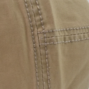 Macro shot of khaki cotton twill fabric with reinforced stitching on beret cap