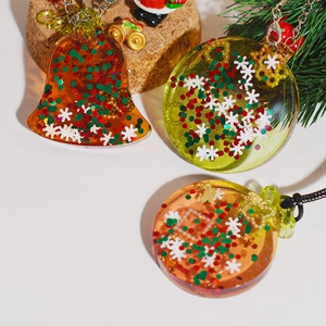 Vue détaillée des breloques de Noël en résine avec paillettes et décorations de sapin
