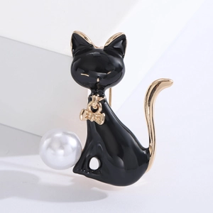 Macro detail of enamel black cat brooch with golden bow pendant and white faux pearl