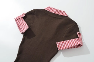 Detail view of the brown ribbed knit top featuring red and white plaid collar and cuffs