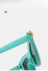Dettaglio di occhiali da sole cat-eye verde menta con strass e accenti di perle