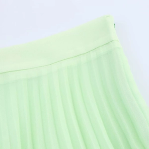 Detail of light green pleated skirt showing waist stitching and invisible zipper