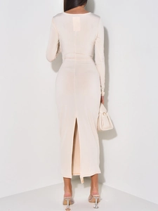 Rear view of an elegant beige long-sleeve evening dress showing a back slit detail
