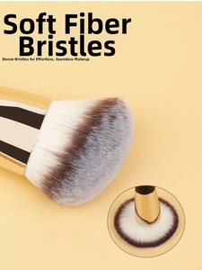 Detail of high-density soft fiber bristles and light gold metallic handle on makeup brush