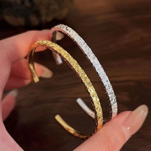 Minimalist adjustable cuff bracelet with hammer-textured finish in gold and silver