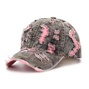 Detail of distressed grey denim baseball cap with pink frayed edges and ripped texture