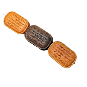 Trois pendentifs en bois de santal avec écritures gravées sur fond blanc