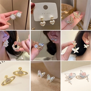Detail showcasing variety of rhinestone cross, butterfly, and pearl earring designs