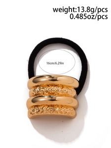 Detail of gold metal hair tie with weight and length specs on a white background