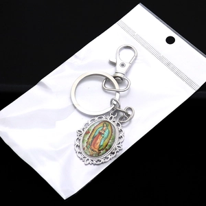 Macro detail of silver alloy keychain featuring the colorful Virgin of Guadalupe icon