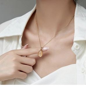 Detailed view of irregular peach aventurine stone pendant on 18K gold plated chain