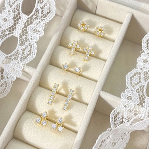 Set of five gold rectangular and geometric stud earrings displayed in a velvet gift box