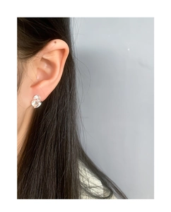 Close-up of S925 sterling silver ruffled geometric stud earrings worn by a model