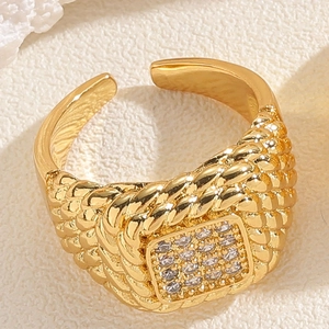Macro shot of gold-plated woven texture ring with a square-cut zircon stone