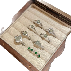 Set of 8 silver-tone rings with green zircon and resin stones in a wooden display box