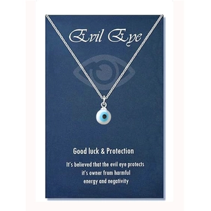 Close-up of blue evil eye pendant on a silver chain with decorative display card
