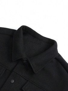 Close-up of the lapel and collar detail on a black wool-textured men's business jacket