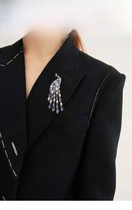 Detail of crystal peacock brooch with colorful rhinestones on a black suit lapel