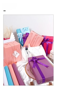 Detailed view of high-quality gift wrapping paper rolls and matching gift boxes with ribbons
