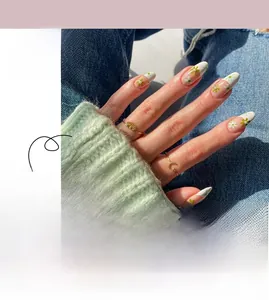 Détail macro de faux ongles French avec fleurs blanches peintes à la main et feuilles vertes
