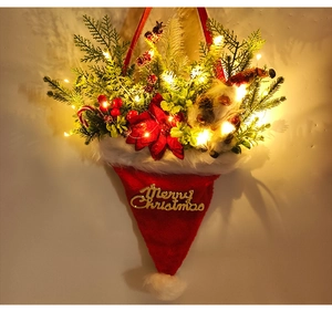 Close-up of lighted Christmas hat pendant with pine needles, berries, and LED glow