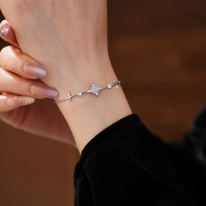 Close-up of adjustable silver starburst bracelet with white zircon on a model wrist