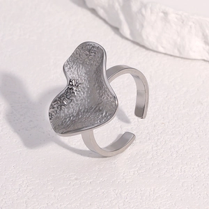 Irregular textured silver stainless steel open ring with hammered finish on white background
