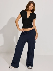 Detail shot of a slim-fit V-neck black knit top styled with blue cargo trousers