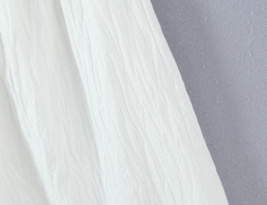 Macro shot of white pleated fabric texture showing high-quality material details