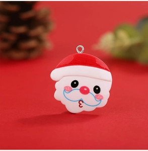Detailed macro view of a resin Santa Claus charm with a metal ring on a festive background