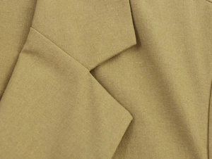 Detail of khaki linen-blend blazer showing notched lapel texture and fabric weave