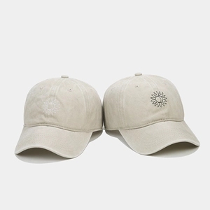Gros plan de casquettes en coton délavé avec des détails de broderie soleil radieux