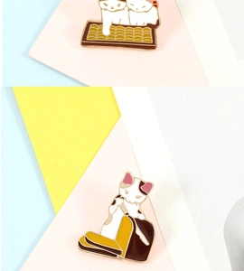 Detailed view of cute cat enamel pins showing a cat on toast and cats in a litter box